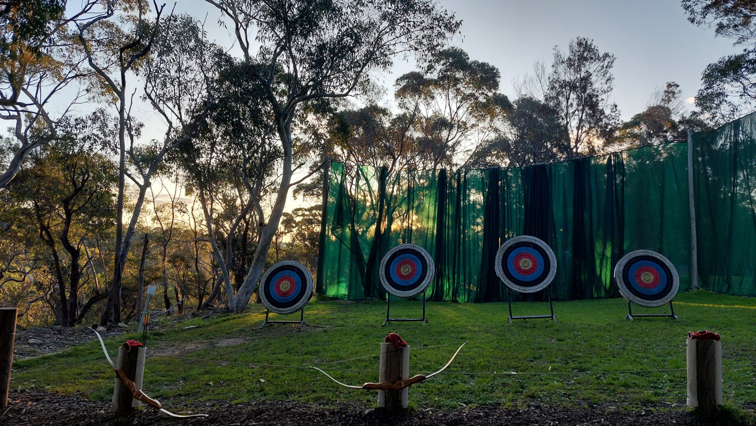 Outdoor archery range with four circular targets and bows on stands at Galston Gorge in August 2022