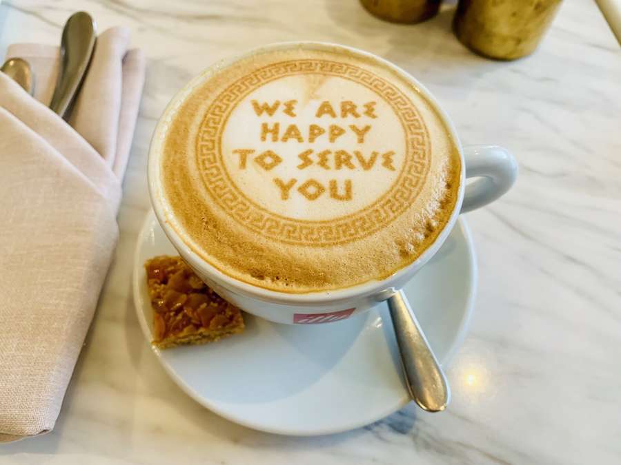 A cappuccino at Warsaw's Cafe Bristol with the words We are happy to serve you in the foam