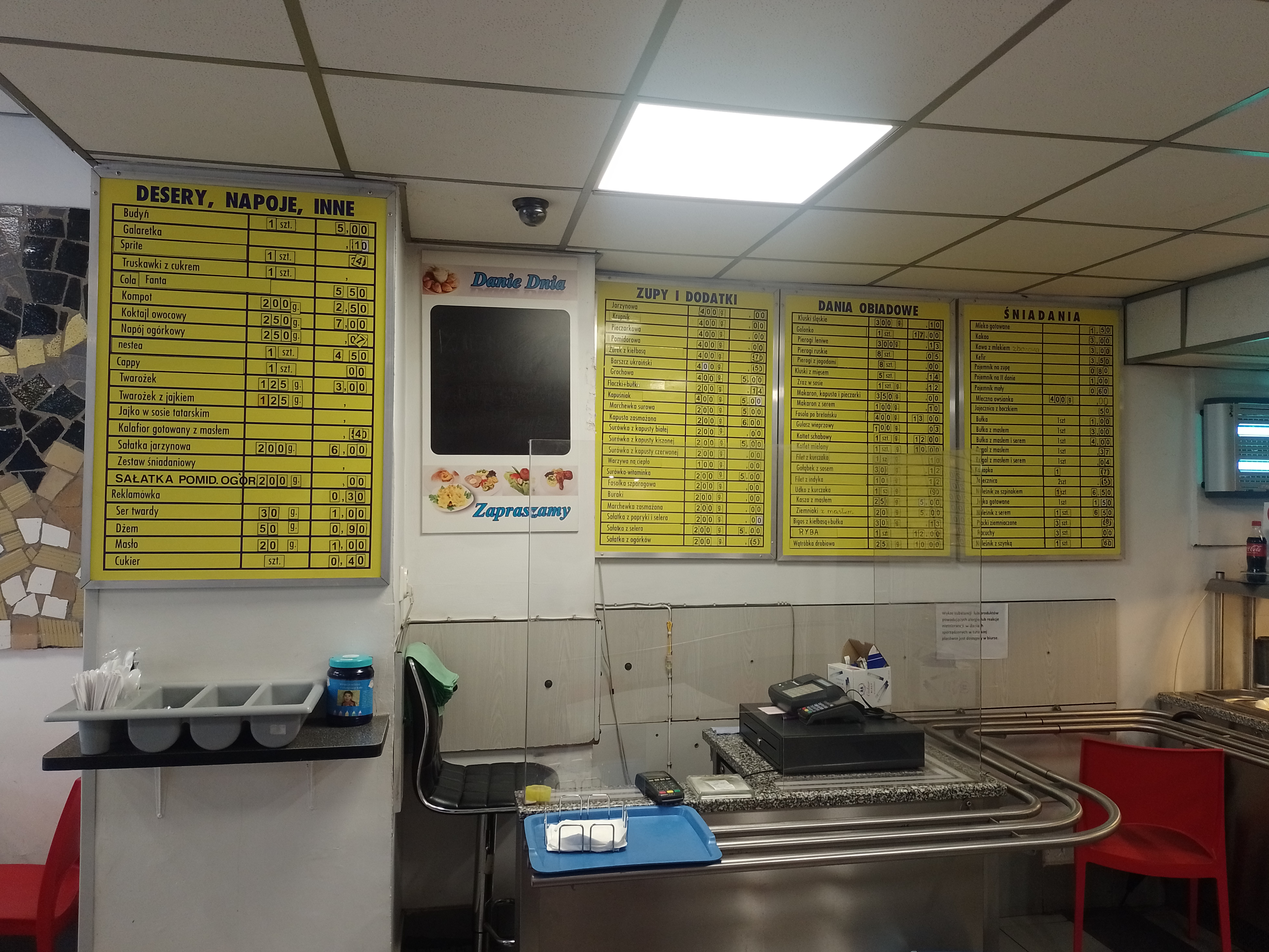 The counter and yellow jadłospis menu boards at Bar Mleczny Europa in Katowice