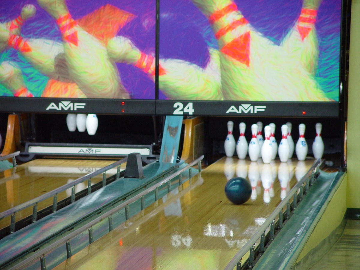 Bowling ball approaching ten pins on an indoor lane