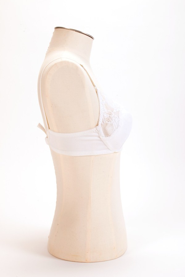 A pale pink bra laid flat, photographed as a museum collection object