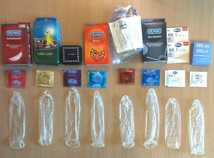 An overview of condoms of different brands laid out on a table