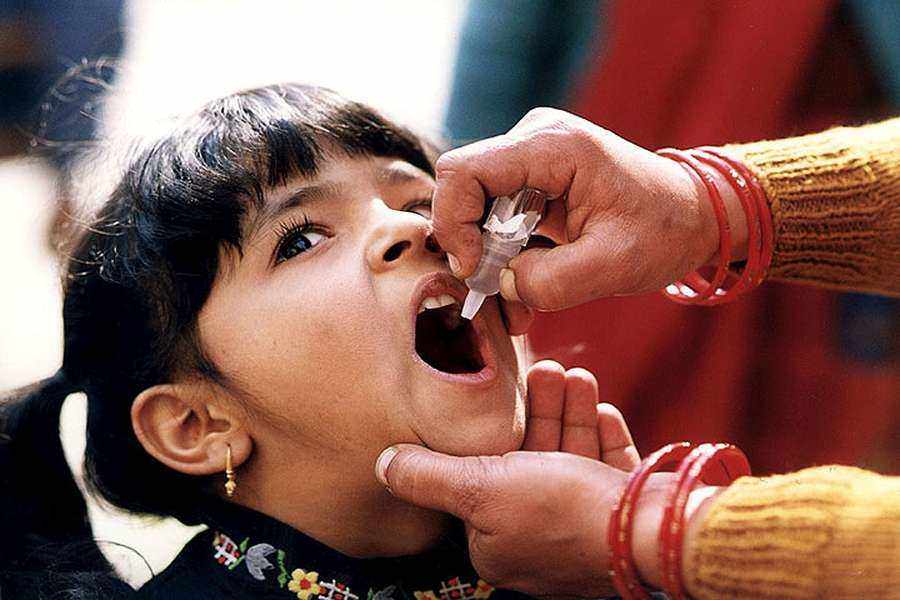 A child receiving an oral polio vaccine - childhood vaccination is a legal duty in Poland