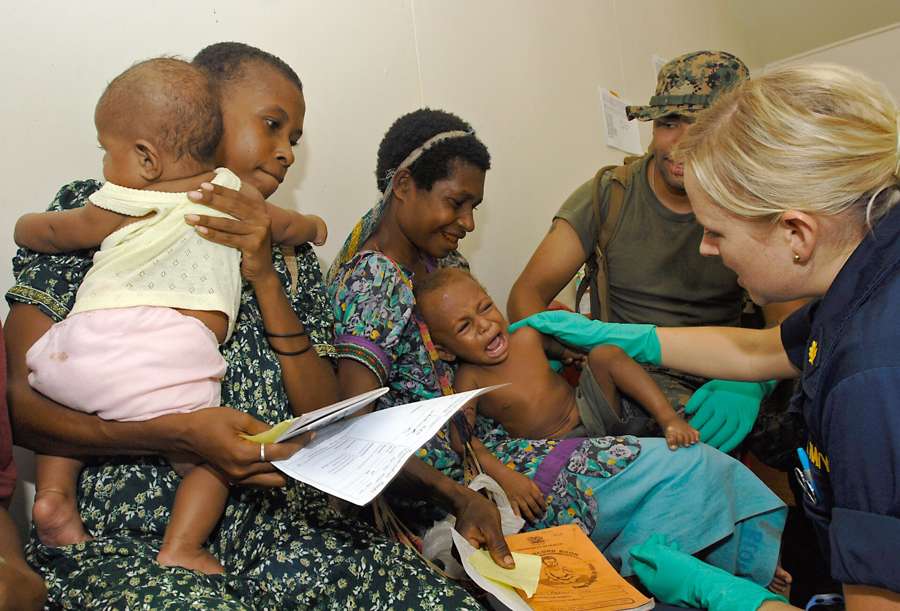 A nurse practitioner calms a child after a vaccination at a clinic