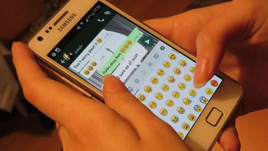 Hands typing a message on a smartphone chat app