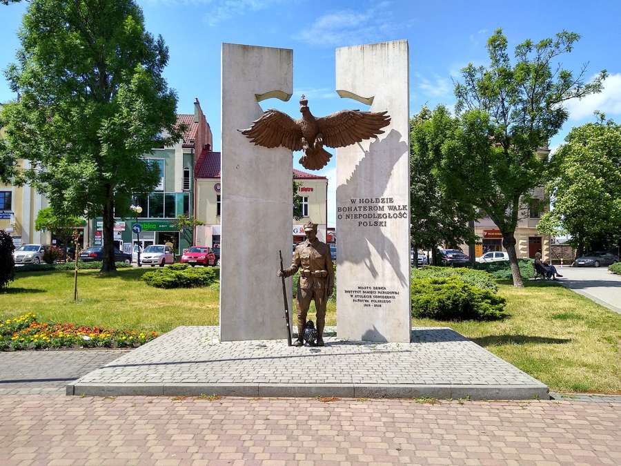 A war memorial with an eagle and a soldier figure on the market square in Dębica