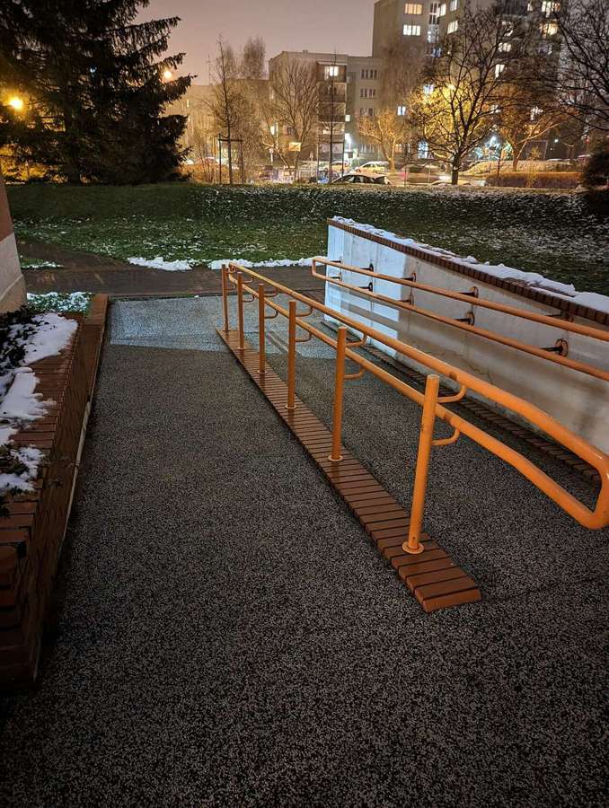 Wheelchair ramp with an orange railing