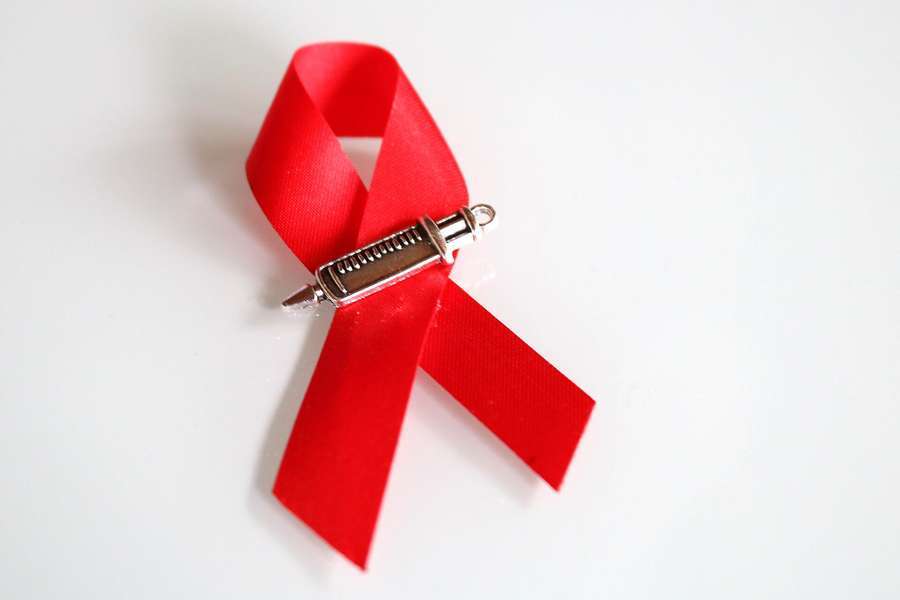 A red HIV awareness ribbon on a white background