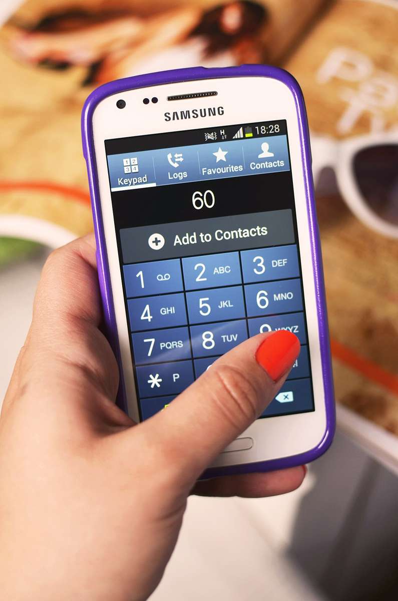 A hand holding a smartphone, illustrative