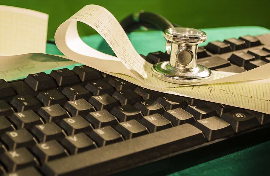 A stethoscope and an ECG printout on a keyboard