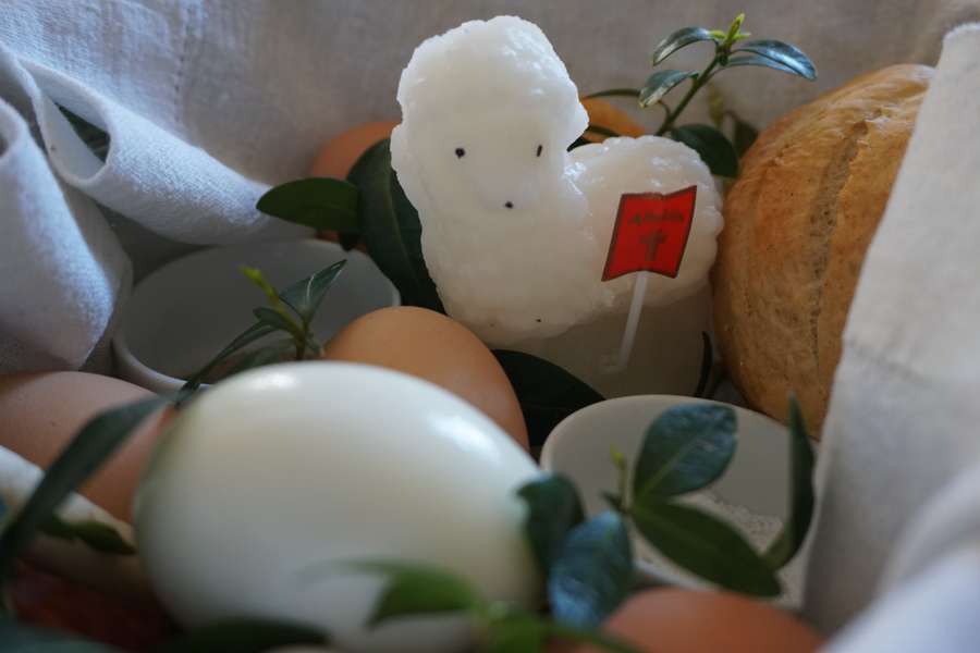 A święconka Easter basket with a sugar lamb, eggs and bread on white linen