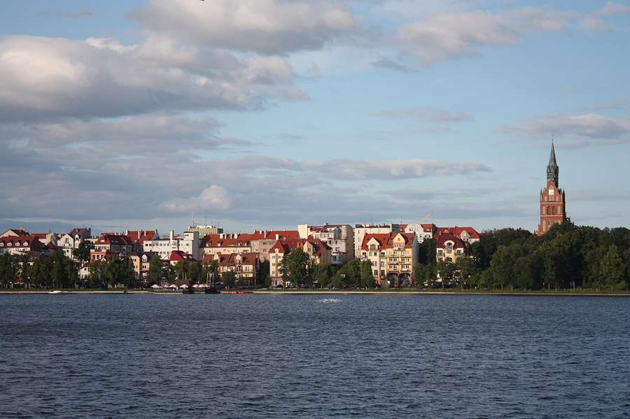 Ełk skyline with a church tower across the lake