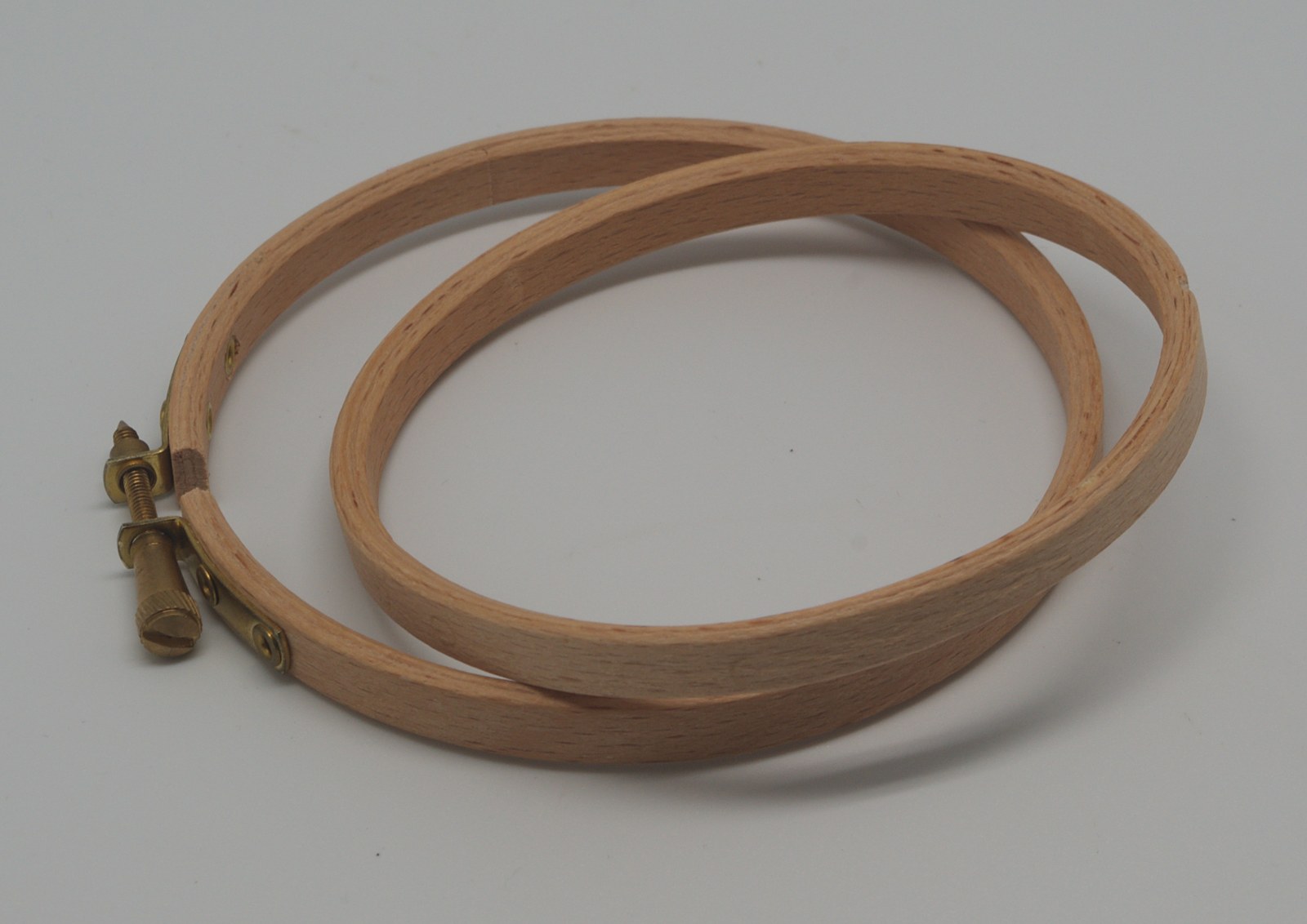 The inner and outer wooden rings of an embroidery hoop with a brass-coloured tightening screw