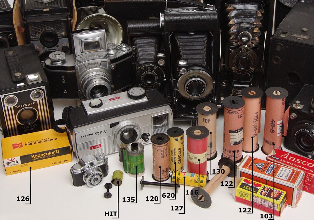 Historical found photographic film and cameras, with film formats labelled