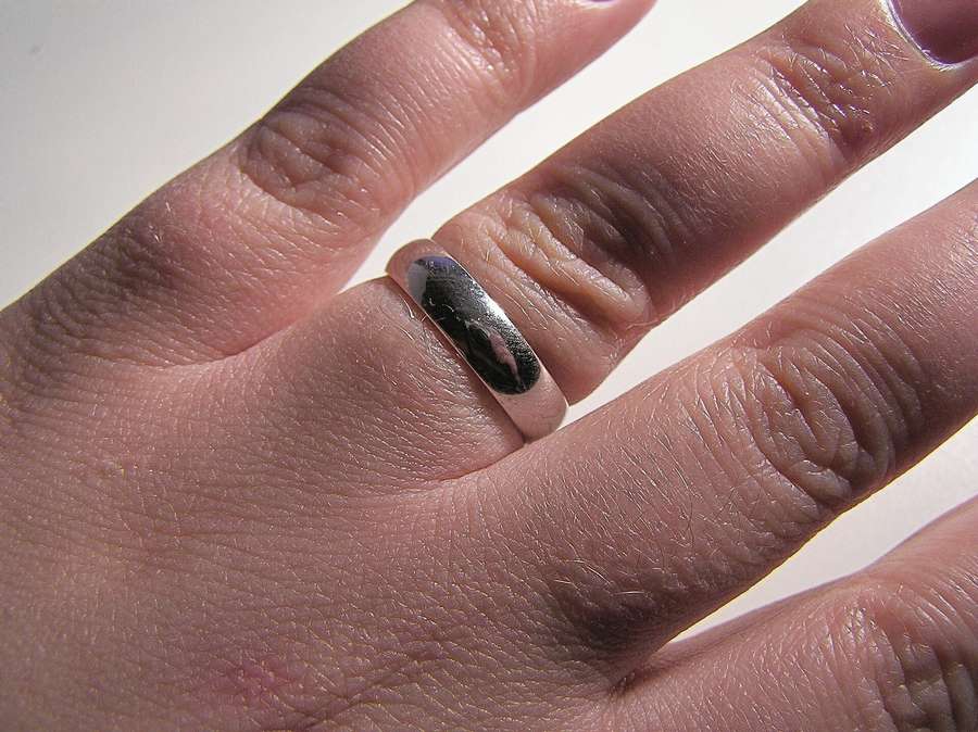 Two gold wedding rings on a plain surface
