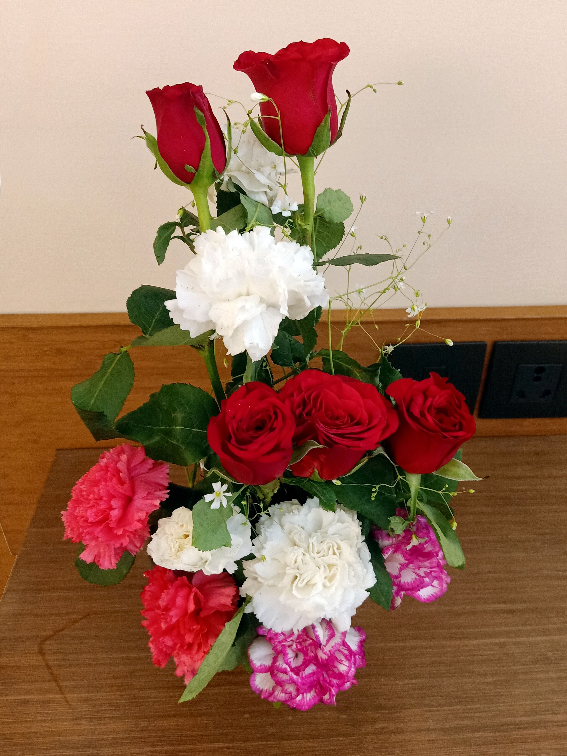 A bouquet of red roses and pink and white carnations, typical Grandparents Day gift flowers in Poland