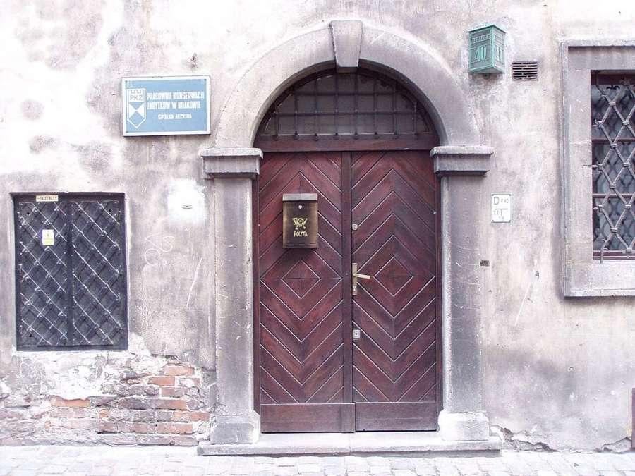 Old tenement doorway in Kraków with a conservation workshop plaque