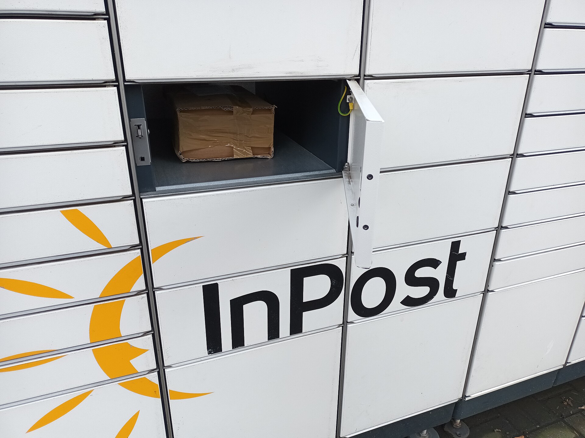 A yellow InPost parcel locker on a street in Poland