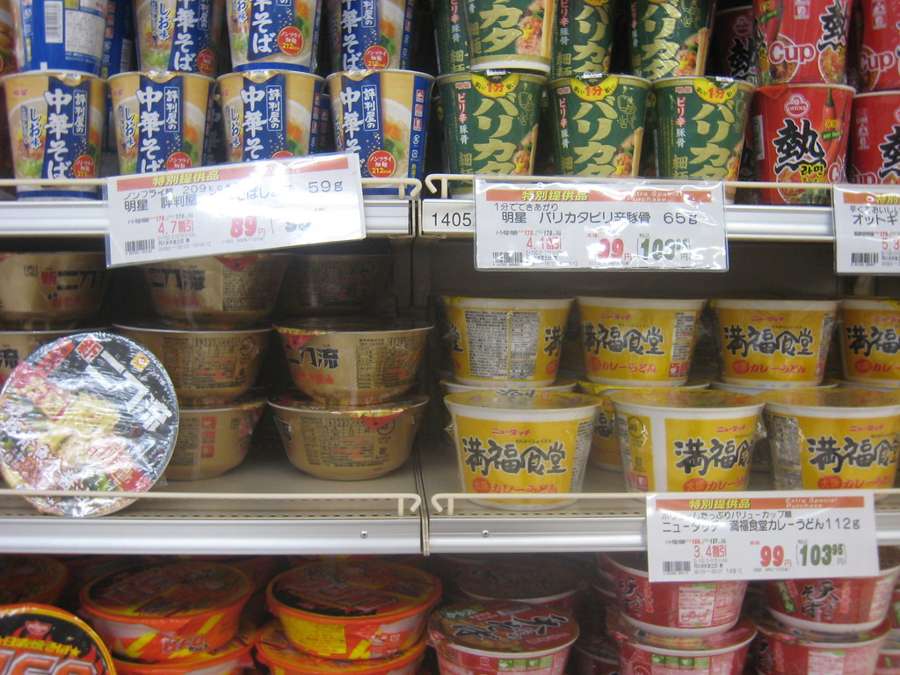 Asian instant noodle varieties stacked on supermarket shelves