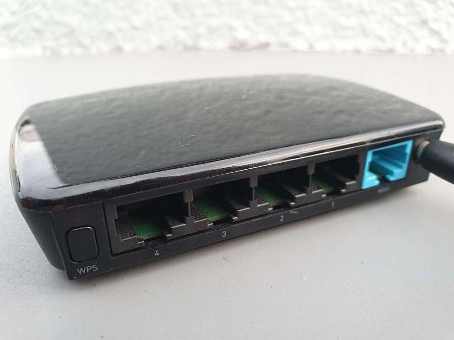 Black Wi-Fi router showing LAN and WAN ports