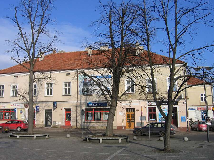 A historic building on the market square in Jasło with bare trees