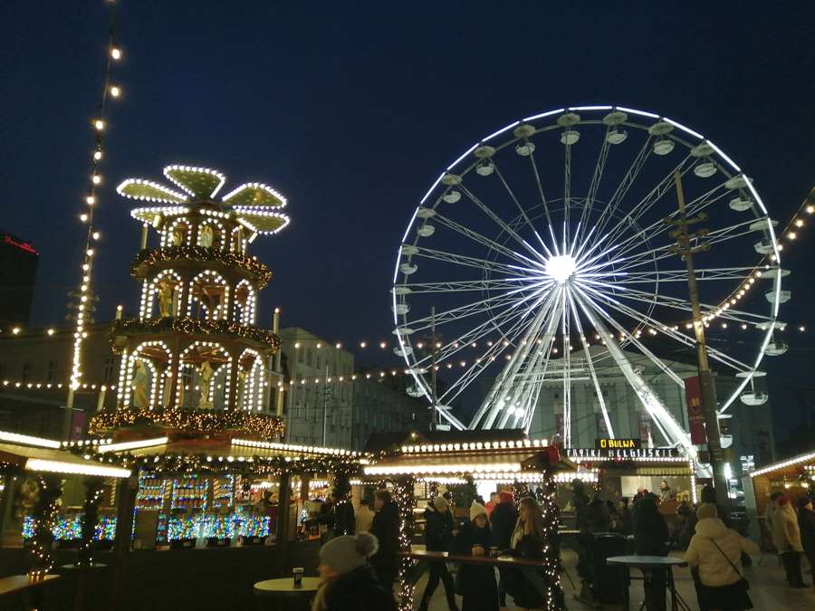The Katowice Christmas market at night, with a Ferris wheel and an illuminated Christmas pyramid