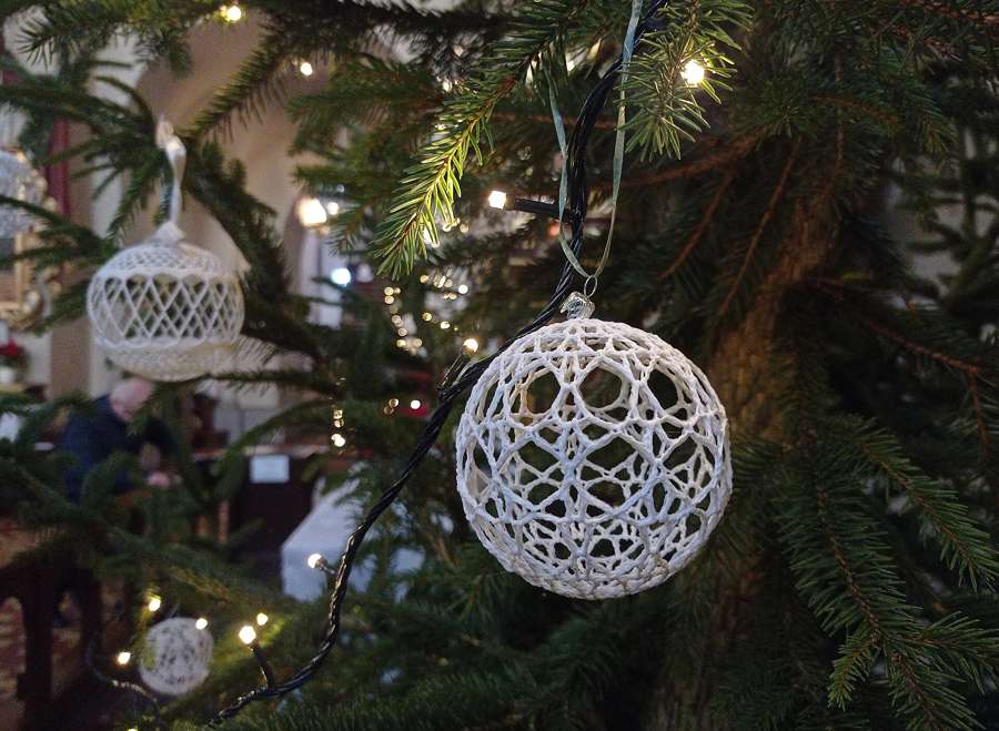 Lace Christmas baubles hanging on a tree inside the Assumption church in Racibórz, Poland