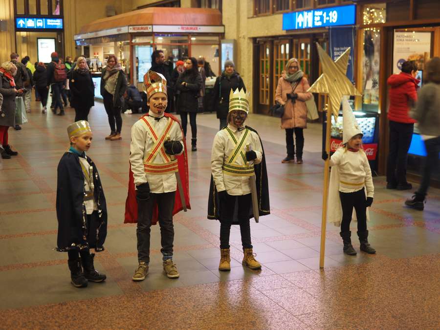 Children dressed as the Three Kings carrying a golden star on a pole, singing as mission carolers