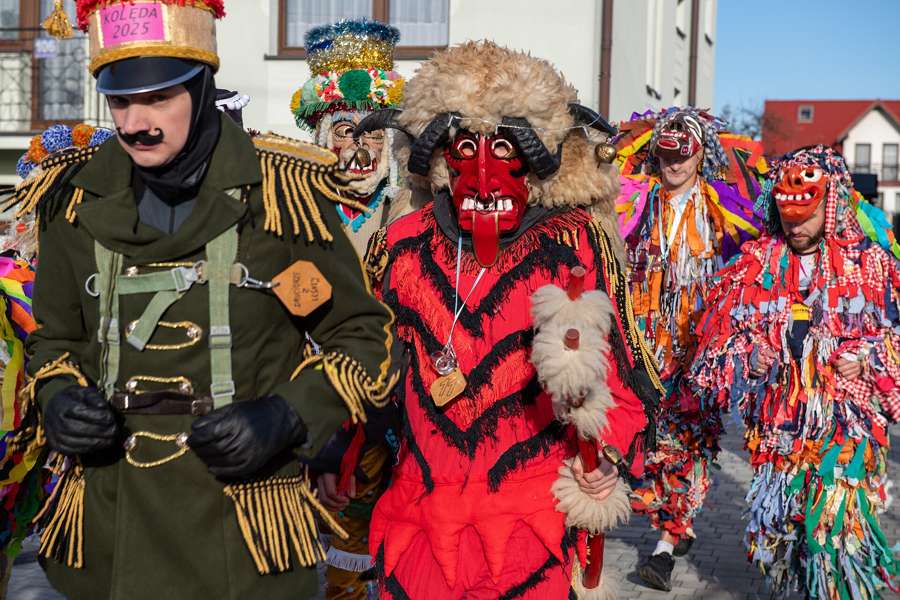 Costumed kolędnicy carollers with a red Turoń beast processing through Leśna, Lower Silesia