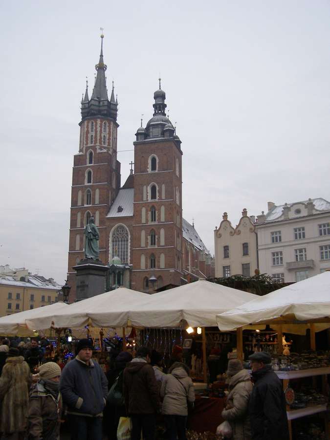 Christmas market stalls on Kraków's Main Square with the towers of St Mary's Basilica behind