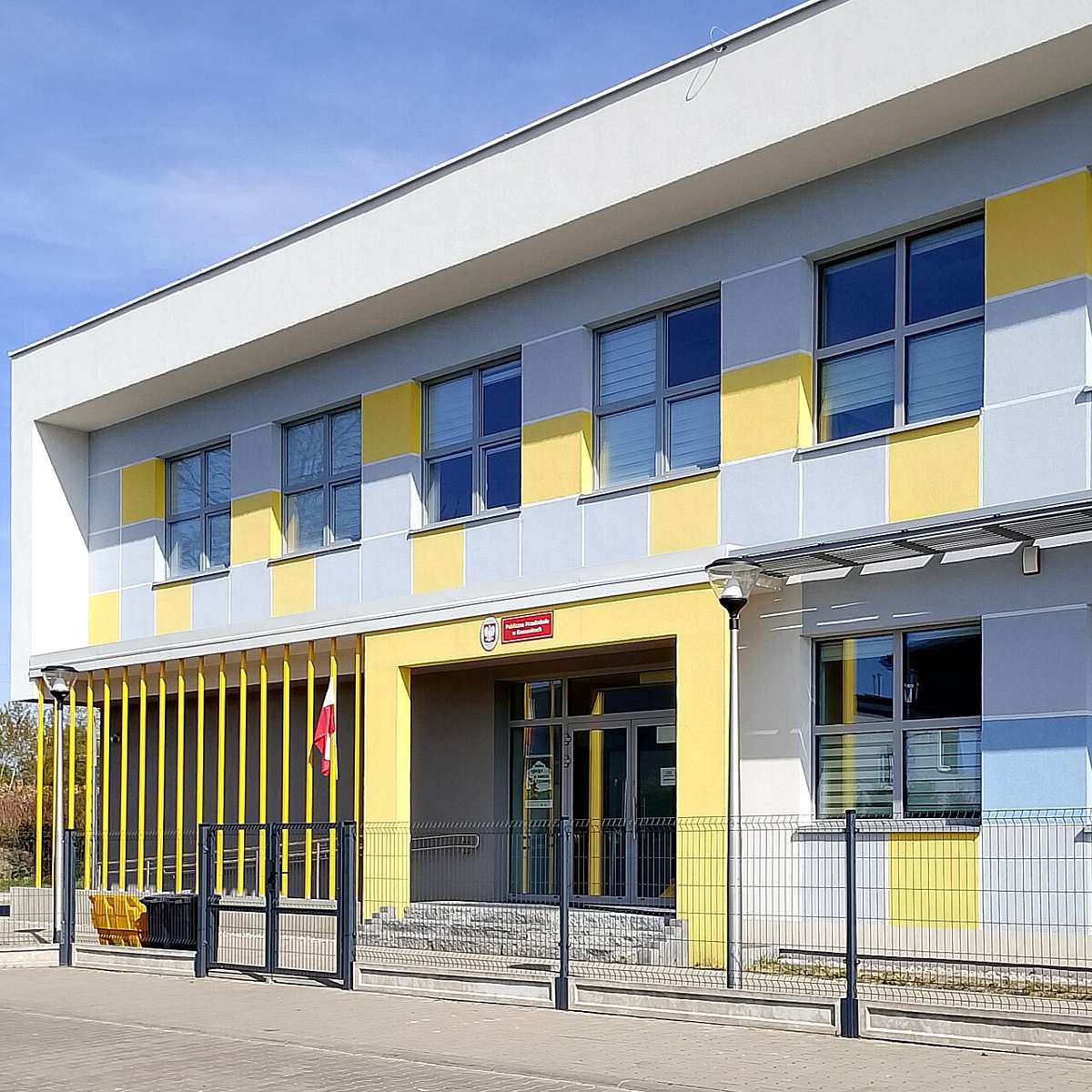 Modern kindergarten building with yellow and grey facade in Gomunice, Poland