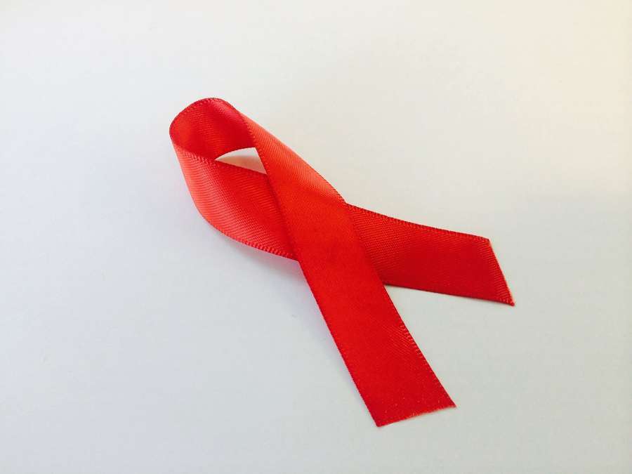 A red awareness ribbon - free and anonymous HIV testing is available in Warsaw without insurance or documents