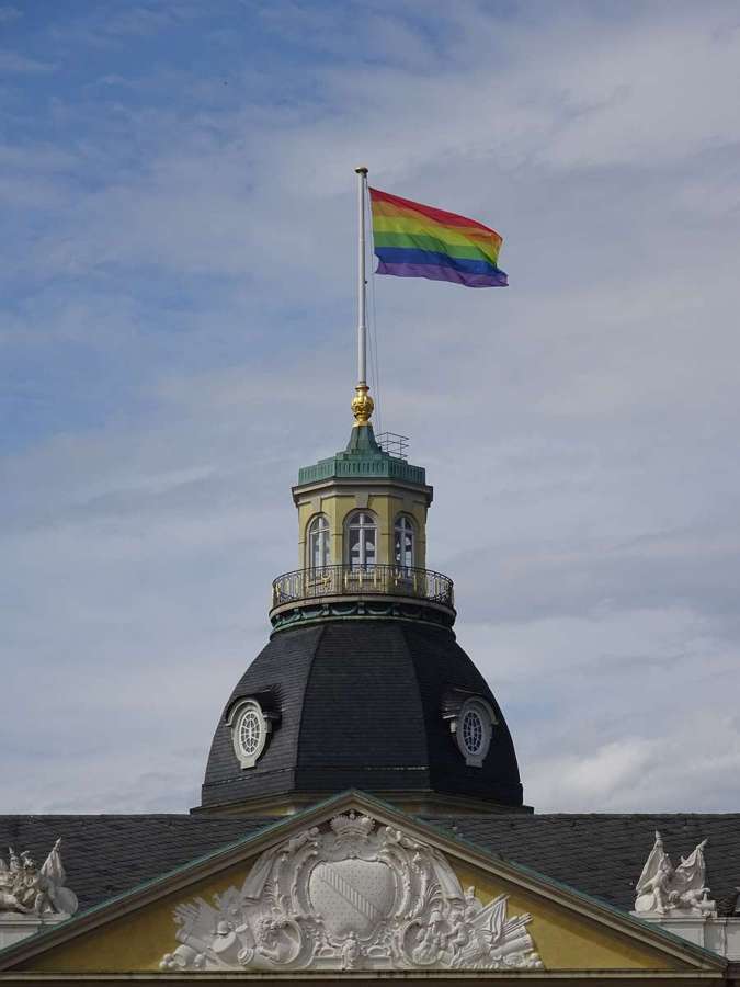 A rainbow pride flag flying from a palace tower