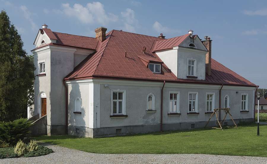 A pale villa-style building with a red roof in Mielec