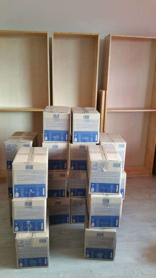 Cardboard moving boxes stacked in an empty room with shelves