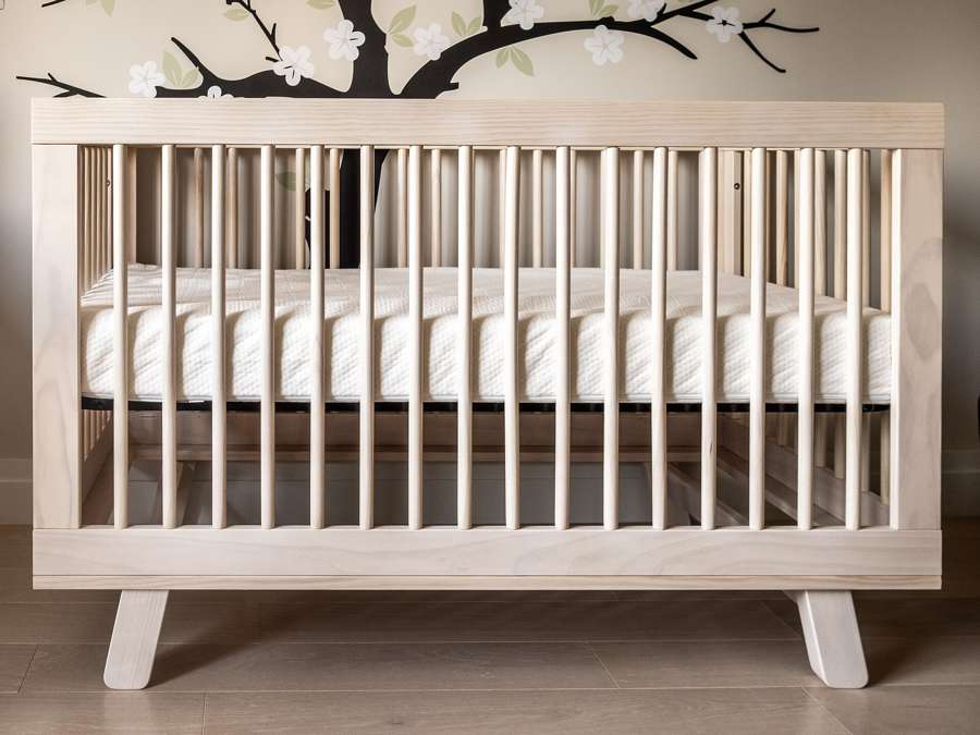 A wooden baby crib in a nursery