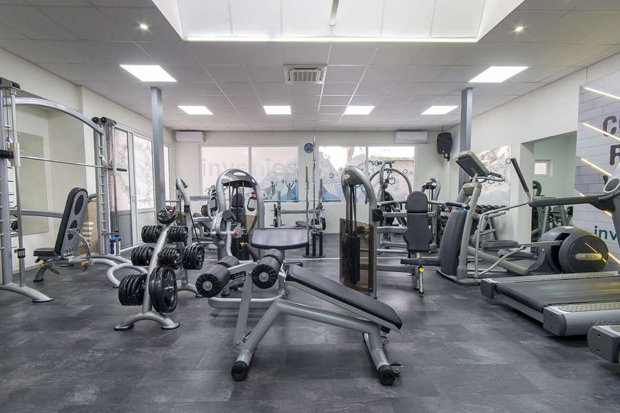 Dumbbells and modern equipment inside a fitness gym