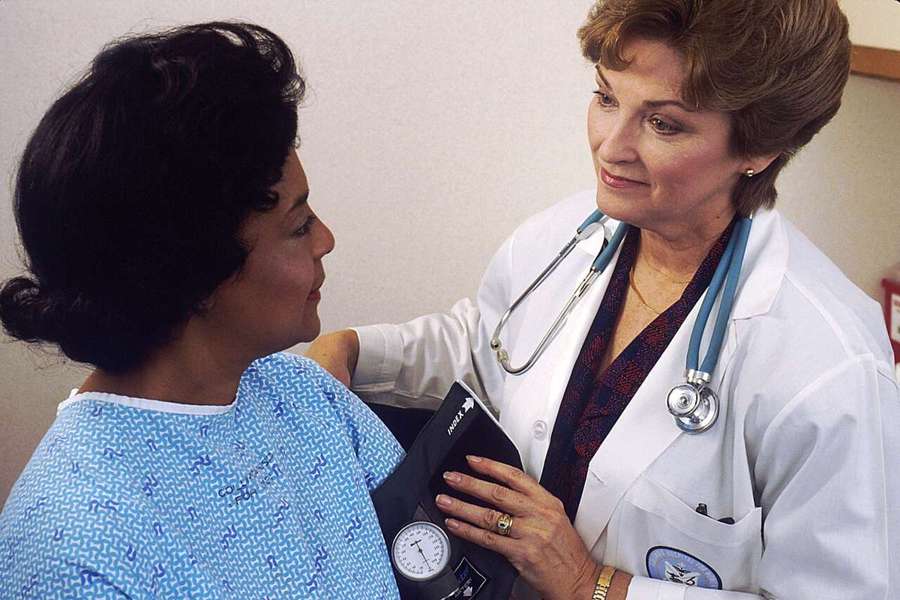 A doctor checking a patient's blood pressure