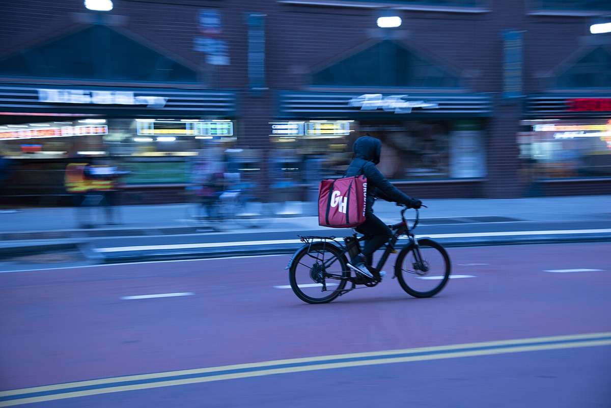 A delivery rider on an e-bike with an insulated bag