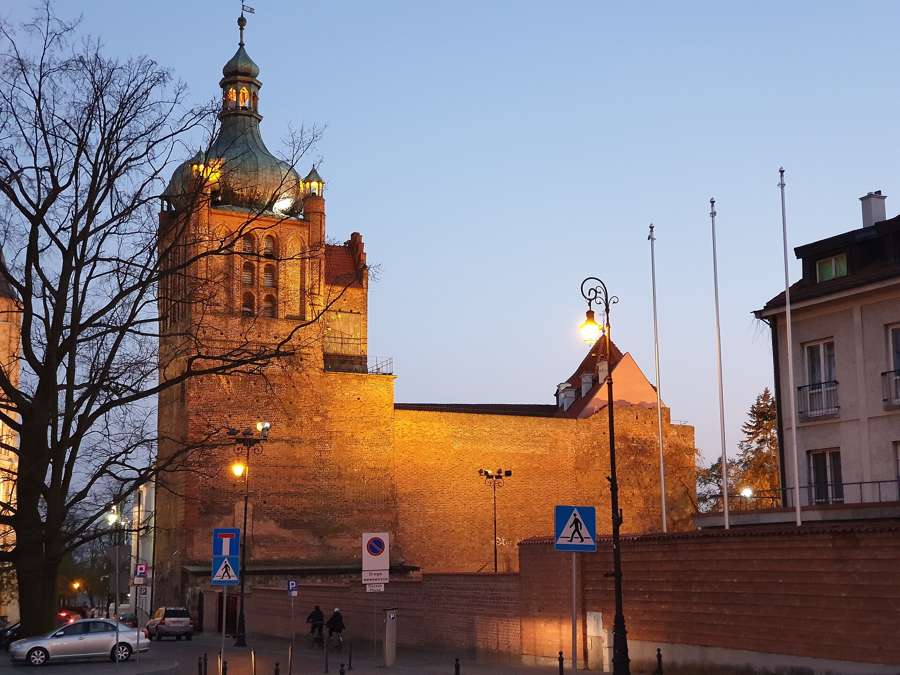 The castle on Tumskie Hill in Płock, lit at dusk above the old town
