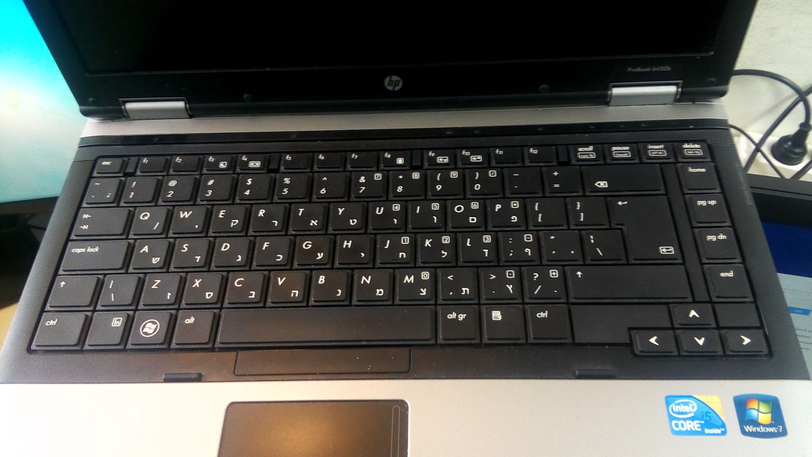An open HP business laptop with a dark screen on a desk