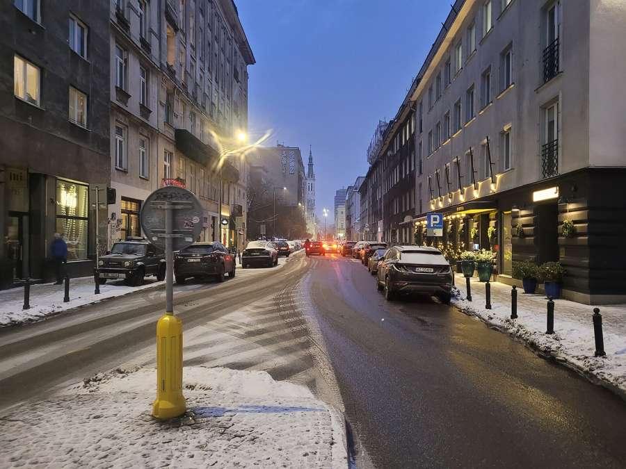 Mokotowska street in Warsaw at dusk in January, with snow on the pavement