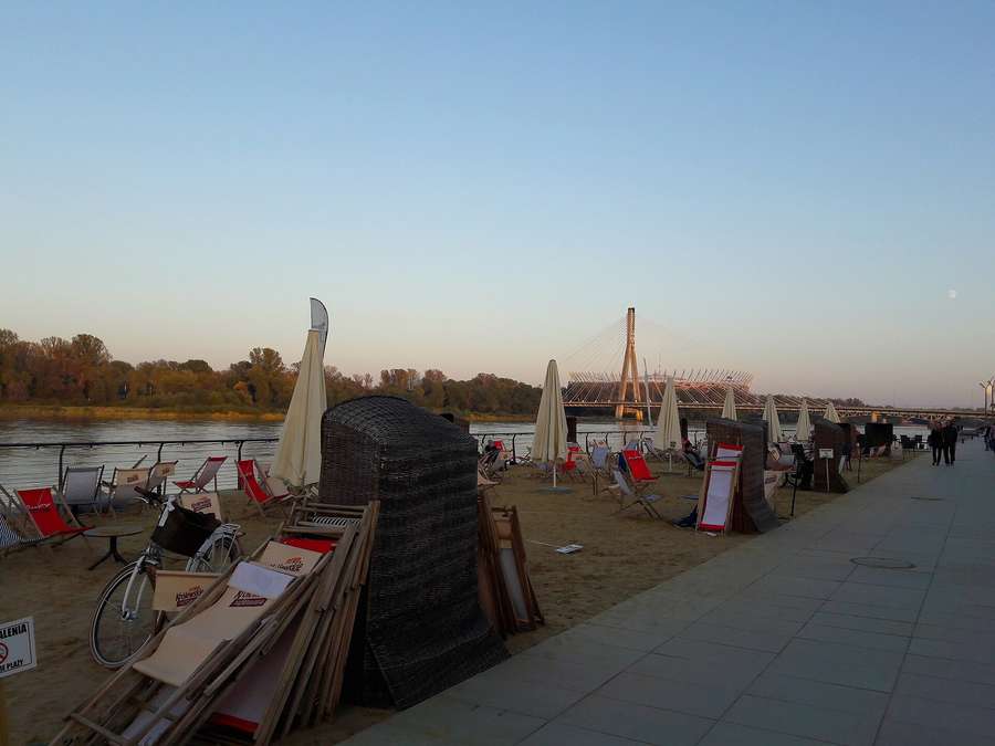 The Vistula Boulevards at dusk with the Świętokrzyski Bridge and the National Stadium behind - Warsaw's most social public space from spring to autumn