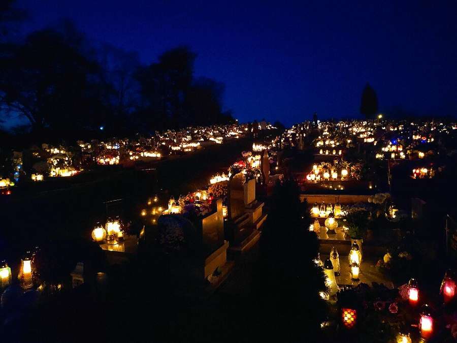 A Polish cemetery glowing with thousands of grave candles on All Saints' Day