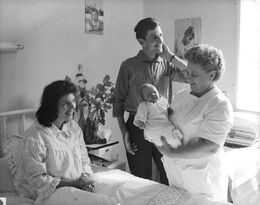 Midwife showing a newborn to the parents