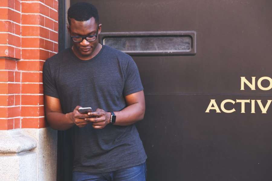 A person using a mobile phone outdoors, an illustrative stock photograph