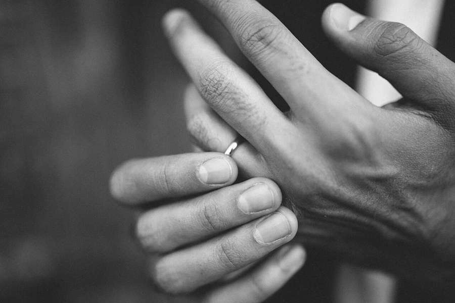 Groom touching a wedding band