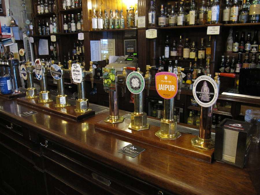 Row of beer taps on a polished pub counter