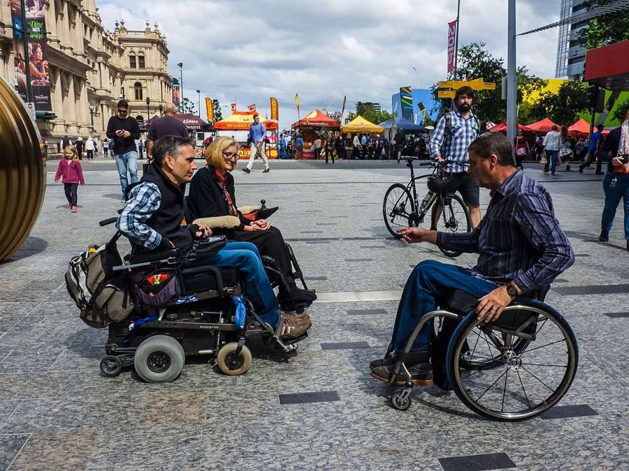 People using wheelchairs in a city street