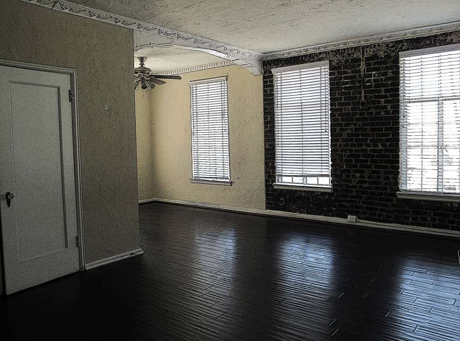 An empty living room with wooden floors awaiting a tenant